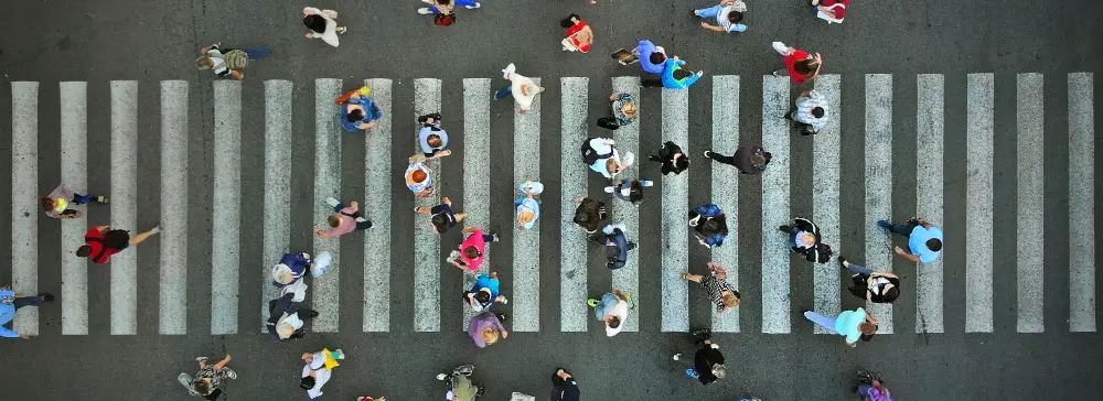 An aerial overhead view of pedestrians crossing at a crosswalk