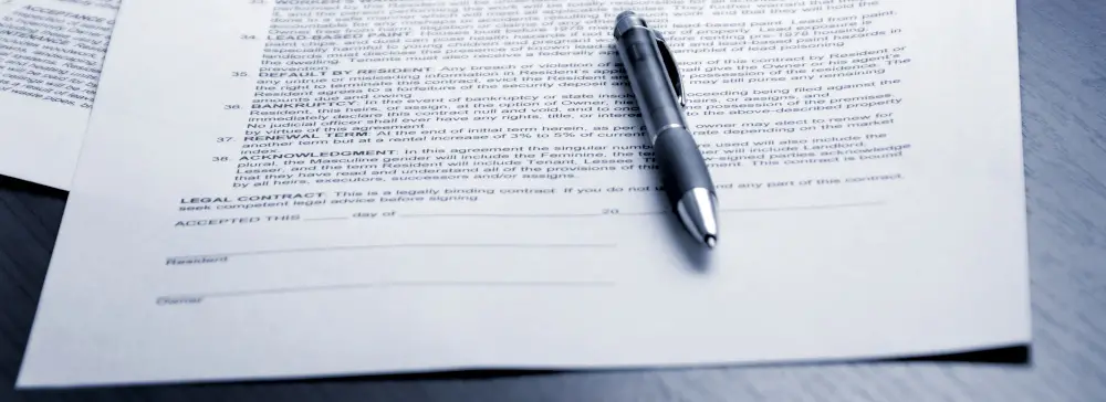 A pen on top of a legal document with a signature line